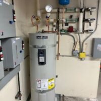 smart-plumbing-solutions-llc-00010 Residential water heater with manifold valves and pressure gauges mounted on wall